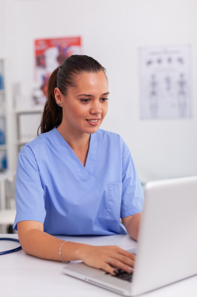 Medical nurse typing on laptop